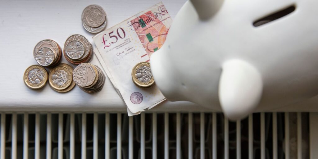 A piggy bank and cash on a radiator
