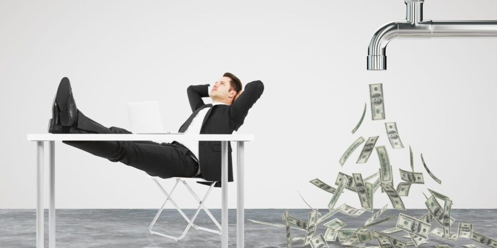 A person sitting in a chair as money appears from a pipe